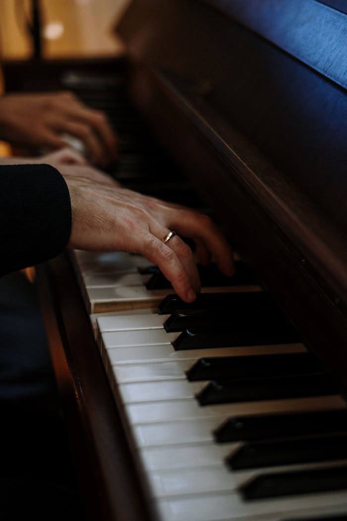 A close-up shot of fingers skillfully playing a classic grand piano keyboard.